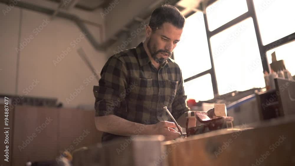 Handsome man in his fourties working with tools and wood at his workplace Handsome man in his fourties working with tools and wood at his workplace