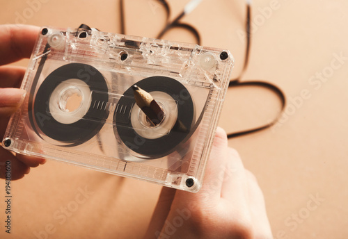 Vintage cassette and pencil to rewind tape on brown background photo
