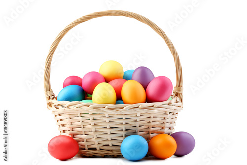 Colorful easter eggs in basket isolated on white background