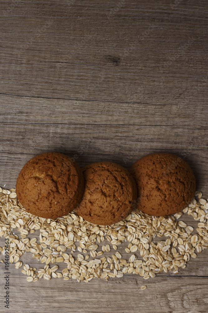 three oatmeal cookies lie on a black plate three oatmeal cookies lie on a black plate