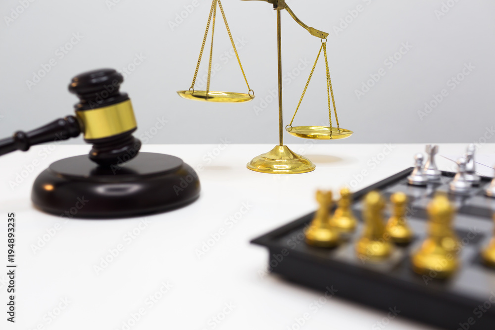 Wooden gavel and gold scales put on white table. Wooden gavel and gold scales put on white table.