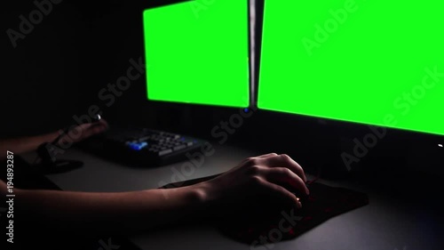 working with two monitors in dark, green screen