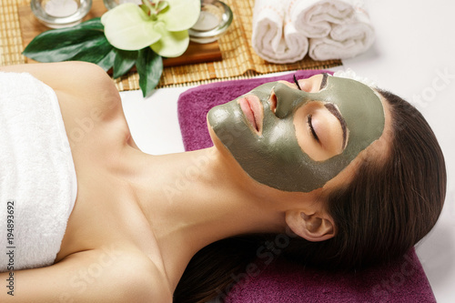 Spa Clay Mask. Woman with clay facial mask and cucumbers on eyes