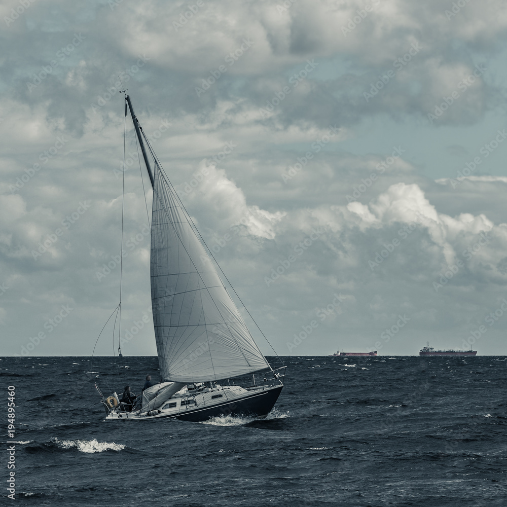 Blue sailboat at storm
