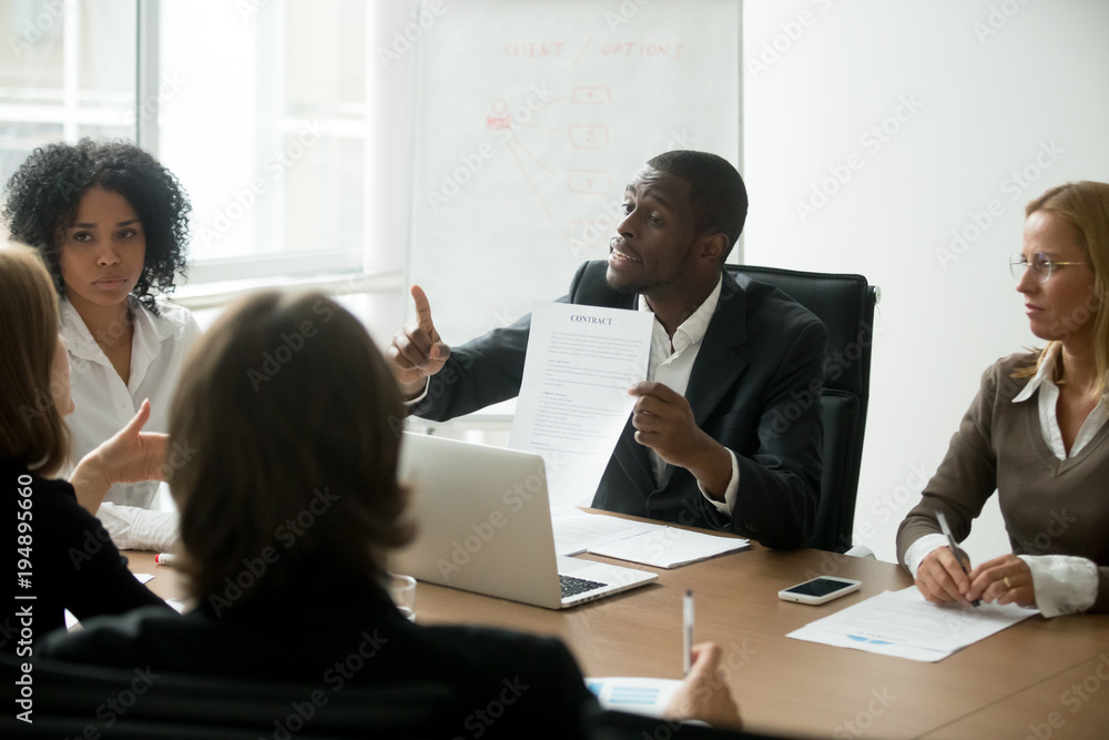 African american businessman disagreeing with contract terms at group multi-ethnic negotiations, black partner arguing about deal conditions or fraud scam pointing at document at multiracial meeting African american businessman disagreeing with contract terms at group multi-ethnic negotiations, black partner arguing about deal conditions or fraud scam pointing at document at multiracial meeting