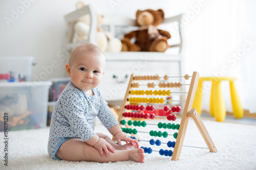 Vászonkép Cute little baby boy, playing with abacus at home