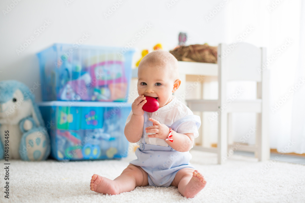 Cute little toddler child, baby boy, in sunny living room playing with Easter chocolate bunny Cute little toddler child, baby boy, in sunny living room playing with Easter chocolate bunny