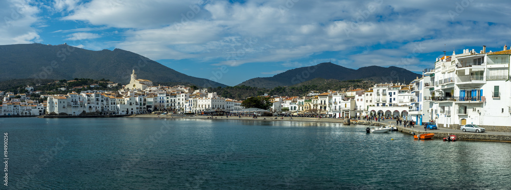 long panorama sur un village typique méditerranéen avec façades blanches et mer bleue