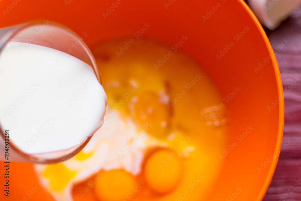 Adding milk to the eggs for whipping. Adding milk to the eggs for whipping.