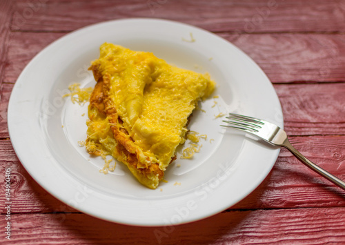 Omelette with grated cheese on a plate.
