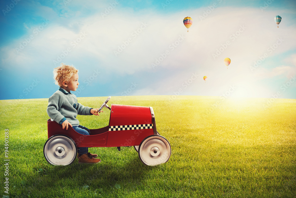 Child with car plays in a green field Child with car plays in a green field