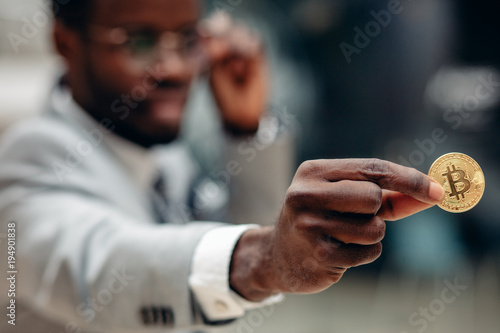 black businessman show golden bitcoin, selective focus photo