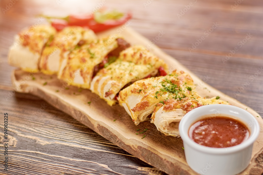 Appetizing burrito with tasty sauce. Burrito wraps with meat, beans and vegetables. Mexican burrito in restaurant. Appetizing burrito with tasty sauce. Burrito wraps with meat, beans and vegetables. Mexican burrito in restaurant.