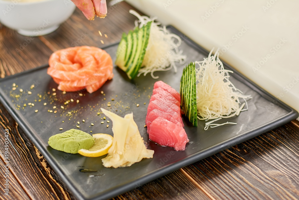 Fresh salmon and tuna on plate. Appetizing sashimi with salmon and tuna on wooden table. Traditional japanese food. Fresh salmon and tuna on plate. Appetizing sashimi with salmon and tuna on wooden table. Traditional japanese food.