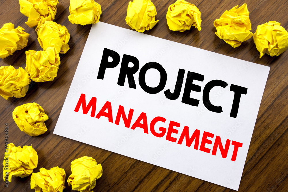 Fototapeta premium Handwritten text showing word Project Management. Business concept writing Strategy Plan Goals Written on sticky note paper, wooden background with space office view with folded yellow paper