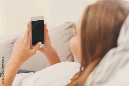 Girl at home chatting online on smartphone