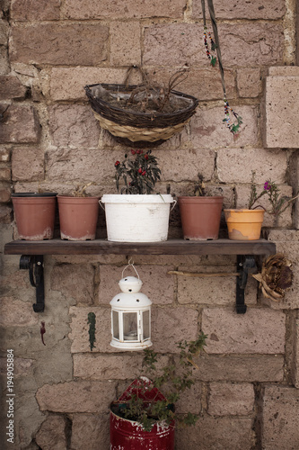 View of decorative objects and flower pots on stone wall in Cunda (Alibey) island.