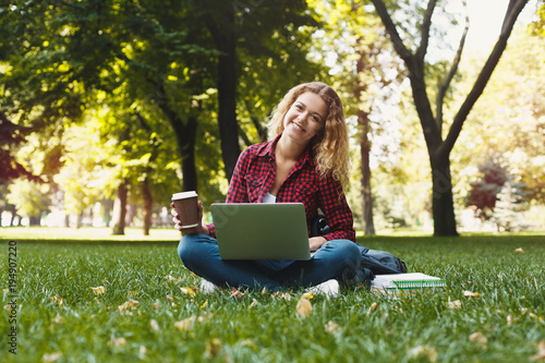 Beautiful young woman using a laptop outdoors