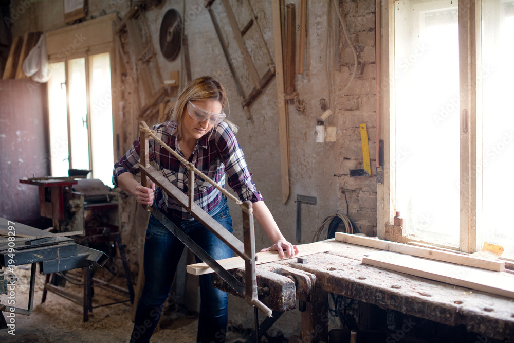 Carpenter woman is cutting wood Carpenter woman is cutting wood