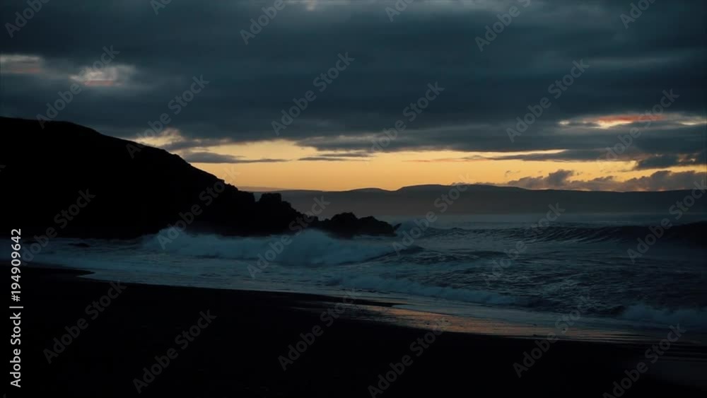 Beautiful sunset on the beach. Waves on stone Beautiful sunset on the beach. Waves on stone