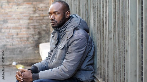 Pensive and sad Black african man alone in the city- poverty, sadness, migration