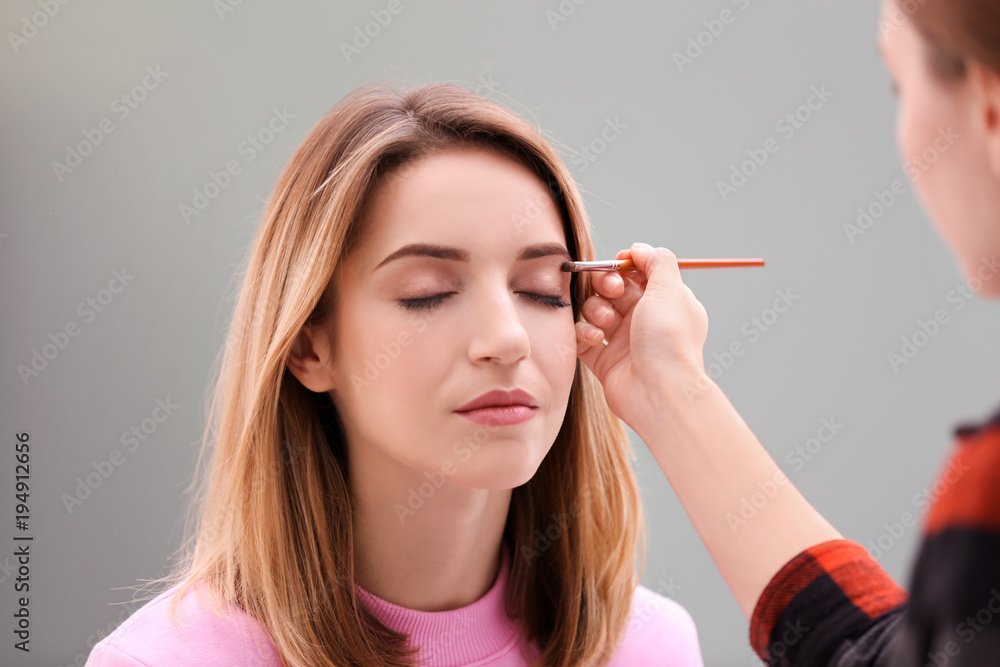 Makeup artist working with beautiful model indoors Makeup artist working with beautiful model indoors