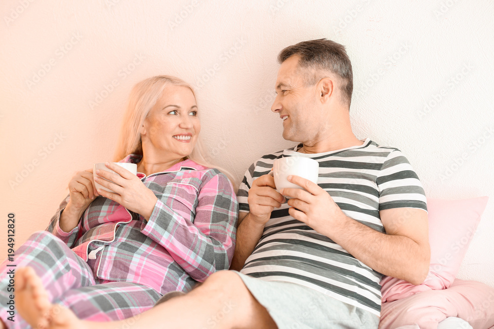 Senior couple drinking coffee on bed together Senior couple drinking coffee on bed together