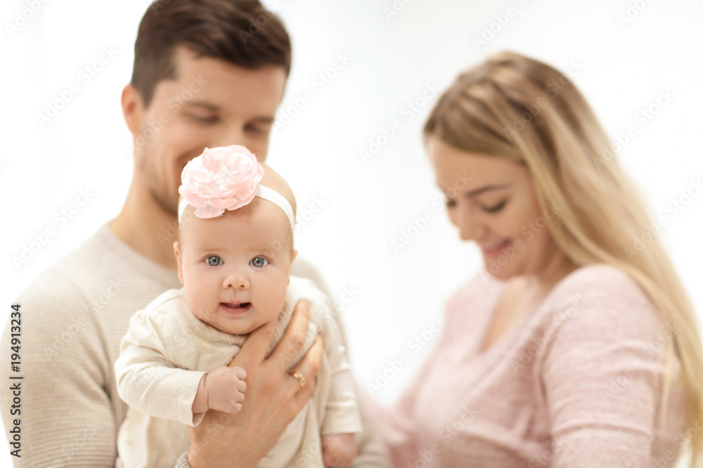 Young parents with baby on light background Young parents with baby on light background