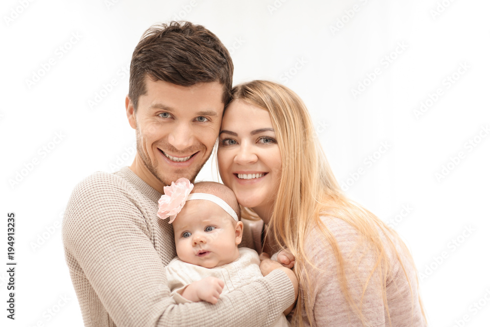 Young parents with baby on light background Young parents with baby on light background