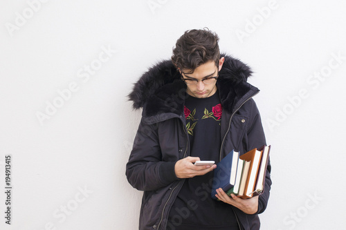 young student with mobile phone and books
