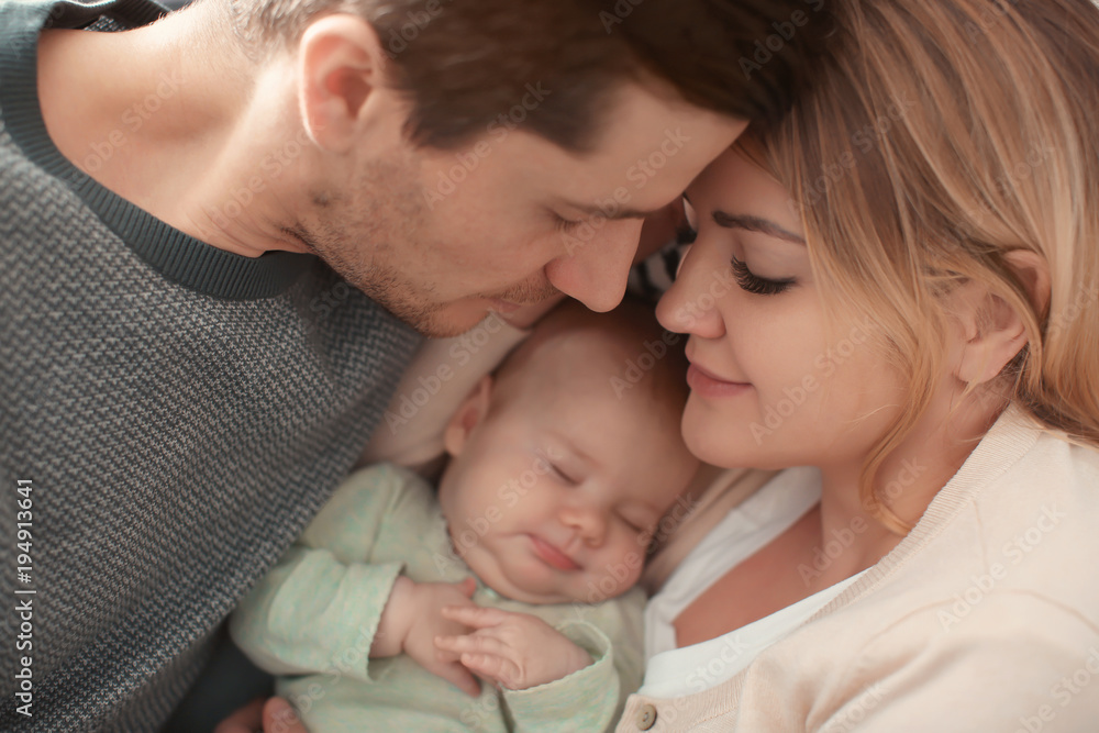 Portrait of young parents with sleeping baby Portrait of young parents with sleeping baby