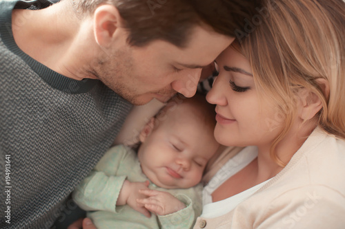 Portrait of young parents with sleeping baby