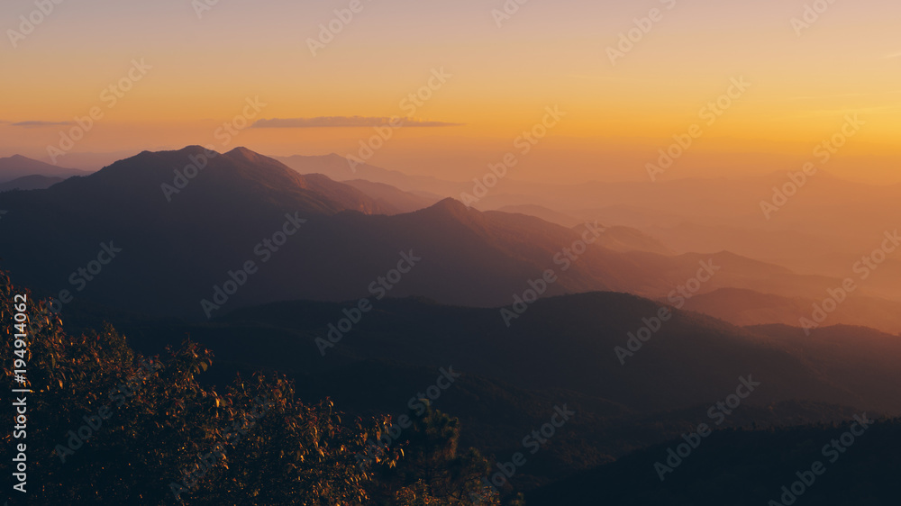The nature after sunset. The sky change to yellow colour. The mountain have fog around.