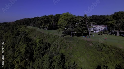 Flying over lake Ontario shoreline towards North West, over water, then cliff, revealing golf club house then city skyline beyond
UNGRADED DLOG FOOTAGE photo