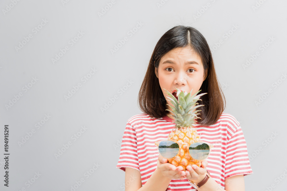 Young girl happy smile and cheerful in red dress and hold two pineapple in hand. Concept summer travel. Young girl happy smile and cheerful in red dress and hold two pineapple in hand. Concept summer travel.