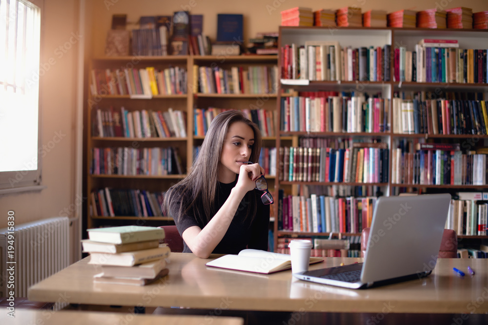 Caucasian female student studying in library Caucasian female student studying in library