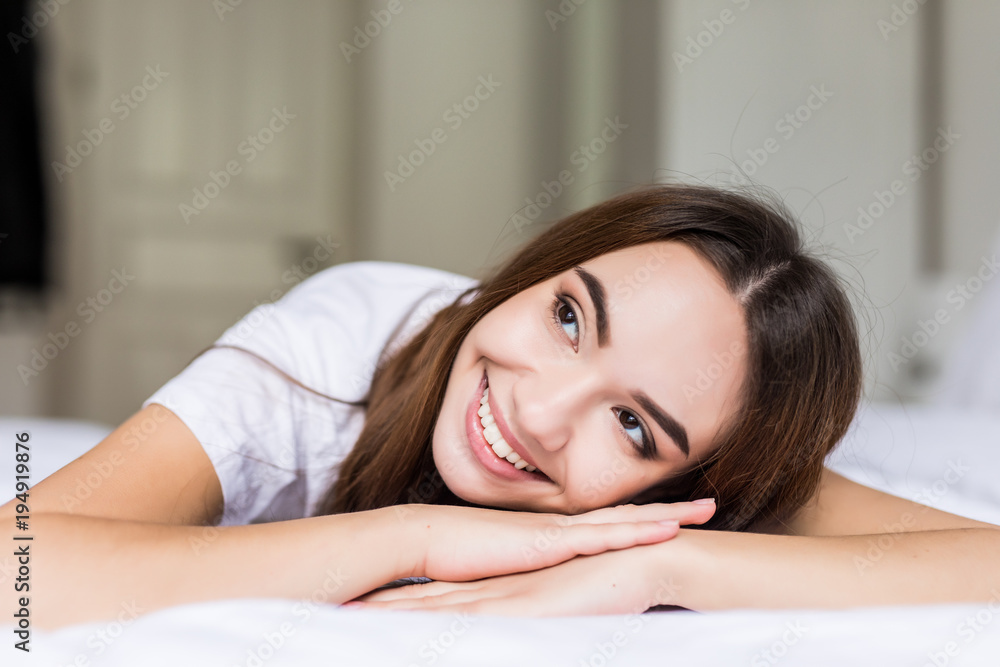 Young beauty woman lying on hands in her bed at home. Young beauty woman lying on hands in her bed at home.