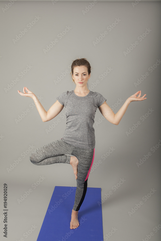 women finds her ballance in dep focus standing on yoga mat