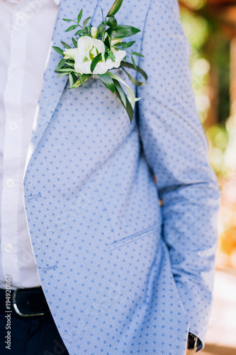 close-up of the groom in a white shirt and blue jacket with a flower bud photo