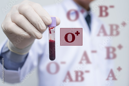 Male doctor showing whole blood in test tube and blood group icon photo