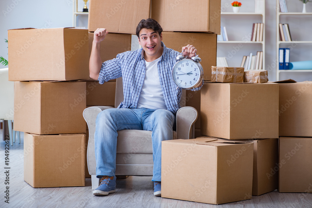 Fototapeta premium Young man moving in to new house with boxes