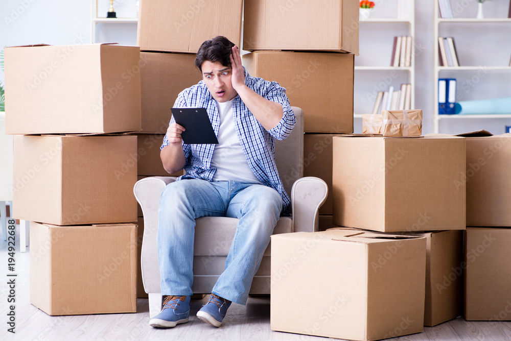 Young man moving in to new house with boxes Young man moving in to new house with boxes