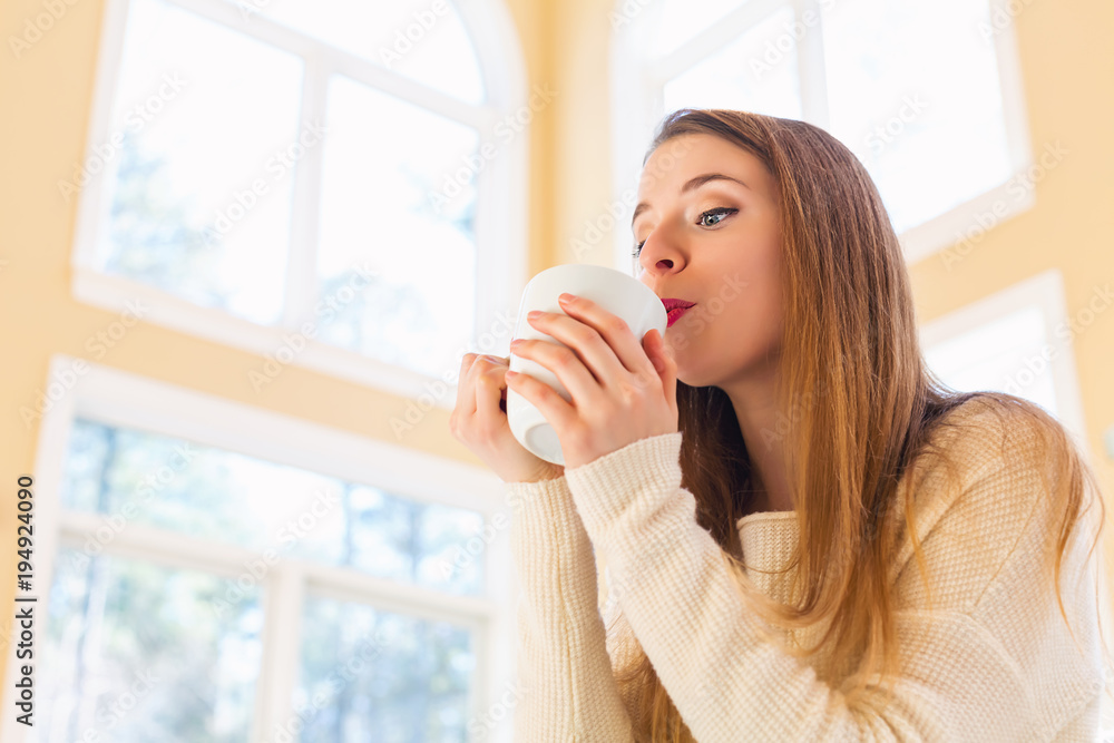 Happy young woman drinking coffee at home Happy young woman drinking coffee at home