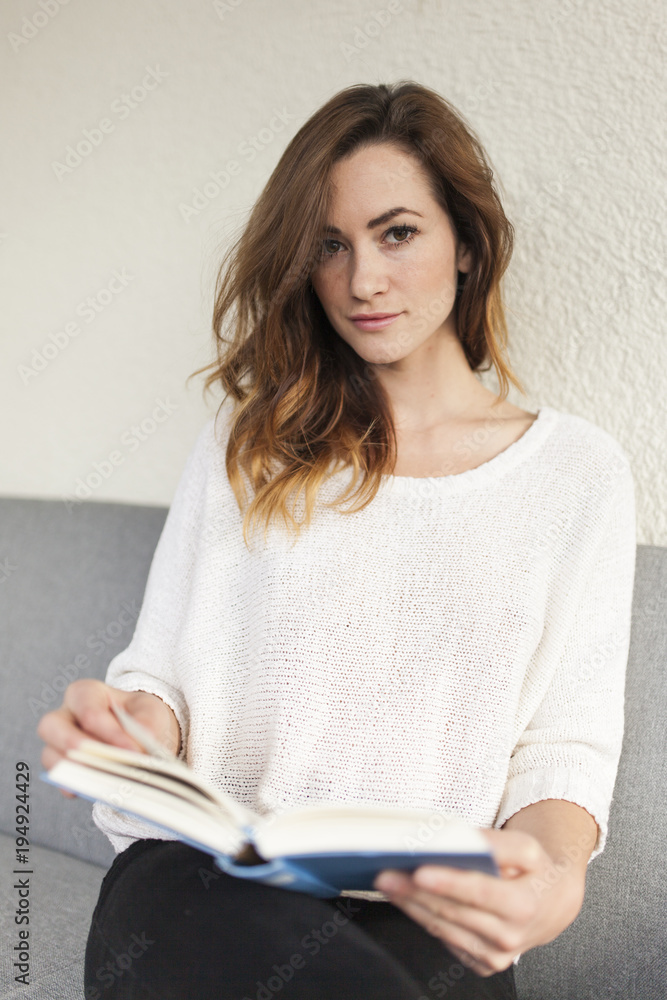 teenager girl holding a book looking into the camera teenager girl holding a book looking into the camera