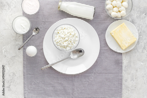 Fresh dairy products. Milk, cottage, cheese, yougurt on grey table with blue tablecloth top view. Monochrome. copy space