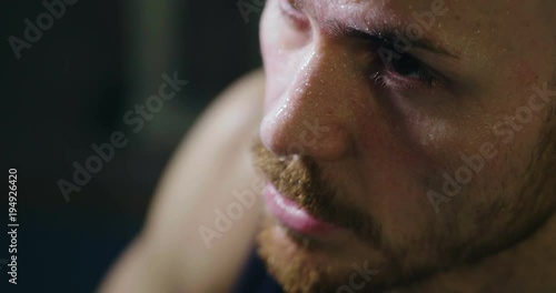Close up of the face of a tired and sweaty man who has just finished a workout and breathes heavily to recover his breath and energy. Concept of: sport, power, determination and tiredness