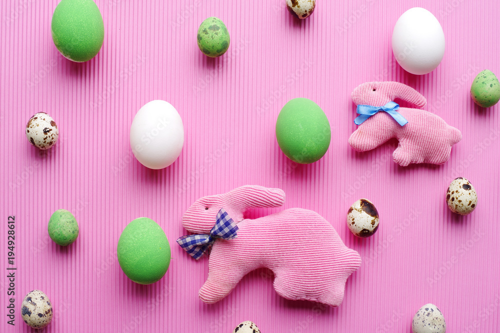 Top view of Easter eggs and rabbits on a pastel pink background. Top view of Easter eggs and rabbits on a pastel pink background.