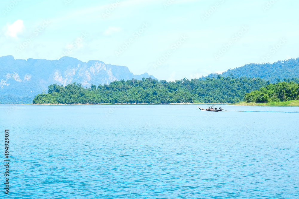 Panoramic views of limestone mountains with crystal green water and long tail boat, southern Thailand.