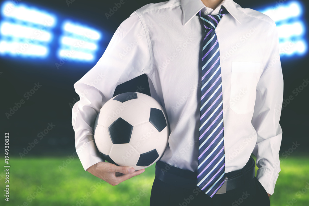 Faceless soccer club manager wearing tie and holding soccer ball Faceless soccer club manager wearing tie and holding soccer ball