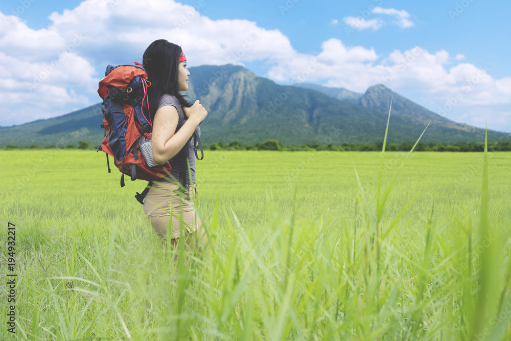 Female hiker standing in the meadow Female hiker standing in the meadow